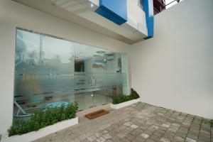 a building with glass windows and a swimming pool at RedDoorz Plus @ Terban Residence in Yogyakarta