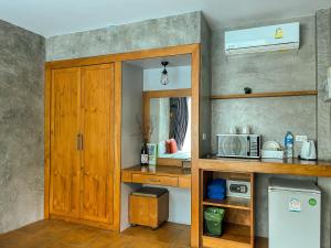 a kitchen with a wooden cabinet and a microwave at BaanMee Phuket near Chalong Pier in Chalong