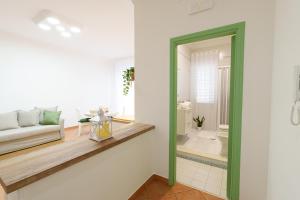 a living room with a green door leading to a bathroom at House Marisa 5 minutes from the airport in Casoria +23 photos