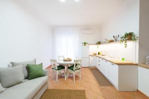 a kitchen and living room with a couch and a table at House Marisa 5 minutes from the airport in Casoria