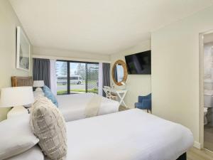 a hotel room with two beds and a window at ibis Styles Port Macquarie in Port Macquarie +101 photos