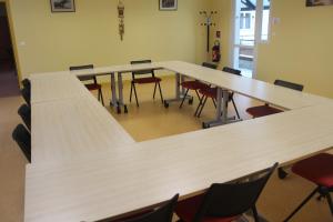 a row of tables in a room with chairs at Hébergement Centre Missionnaire Saint Jacques in Guiclan
