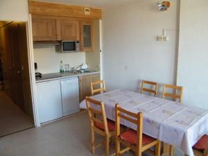 a kitchen with a table and chairs and a kitchen with a table and a kitchen at Roche Blanche 50 in Val Thorens