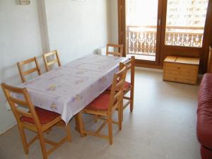 a dining room table and chairs with a white tablecloth on it at Roche Blanche 50 in Val Thorens