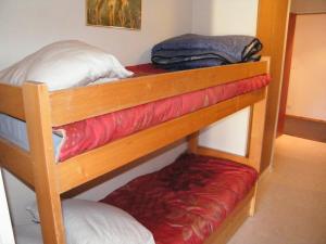 two bunk beds in a room with red padding at Roche Blanche 50 in Val Thorens
