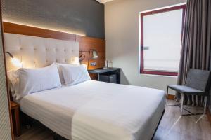 a hotel room with a large bed and a window at Eurostars Amara in Donostia-San Sebastián