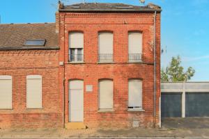 an old red brick building with white windows at Dentelle in Caudry +8 photos