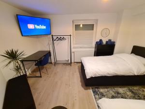 a bedroom with a bed and a tv on the wall at Apartment Royal Blue by Maimark in Seckenheim