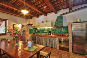 een keuken met een houten tafel en een keuken met groene tegels bij Villa Delle Vigne in Novilara