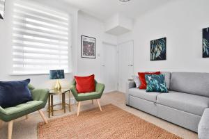 un salon avec un canapé et deux chaises dans l'établissement The Caerphilly Hideaway – Modern 3-Bed Escape, à Caerphilly