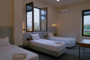 a hotel room with two beds and two windows at Camp Hotel Pura Vida in Tbilisi City