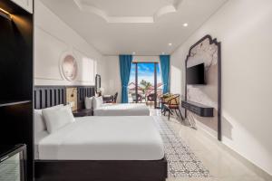 a hotel room with two beds and a living room at ELC Boutique Hoi An Hotel in Hoi An