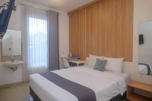 Habitación de hotel con cama blanca y lavabo en Ngampilan Residence Yogyakarta Mitra RedDoorz, en Ngabean 44 fotos más