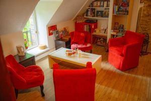 Una sala de estar con sillas rojas y una mesa. en La Suite Richarvilloise, en Richarville