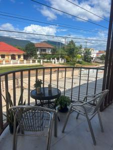 a table and chairs on a balcony with a view of a street at KL's Coffee & Hostel in Pakse