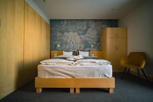 a bedroom with a bed with a painting on the wall at Eleven Business & Sport Hotel in Jászárokszállás +81 photos