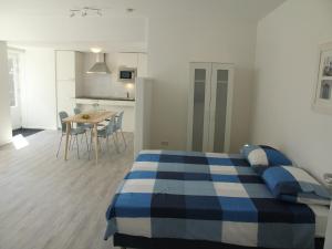 a bedroom with a blue and white bed and a kitchen at Stunning apartment in Schoorl, North Hollandâ you can bike to the beach in Schoorl