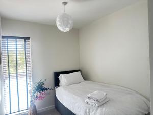 a bedroom with a bed with two towels on it at 4 Bed House - Sleeps 7 - Pets - Parking - Wifi in Bushbury