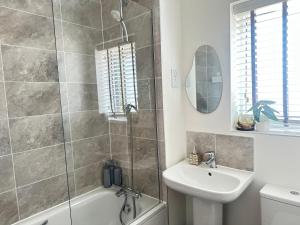 a bathroom with a shower and a sink and a tub at 4 Bed House - Sleeps 7 - Pets - Parking - Wifi in Bushbury