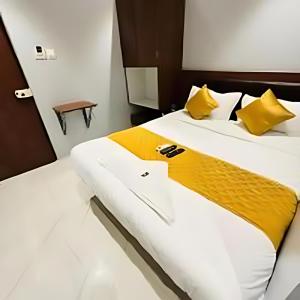 Un dormitorio con una cama grande con almohadas amarillas. en PWI Inn, en Bombay 5 fotos más