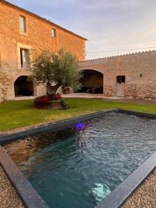 a swimming pool in a yard next to a building at Mas Piarnau in Vilasacra