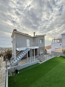a large house with a balcony and a lawn at Eleni's Seaview House in Saronida