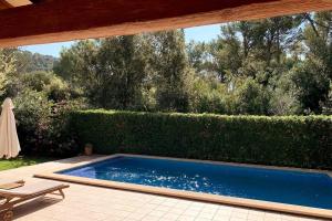 a swimming pool in a yard with a hedge at Nispero in Sa Pobla +8 photos