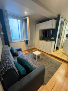 un salon avec un canapé et une télévision dans l'établissement Appartement Cauterets 2 personnes Studio 10, à Cauterets 3 autres photos