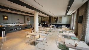 ein Restaurant mit Tischen und Stühlen und einem Buffet in der Unterkunft Petit Palace Tamarises in Getxo