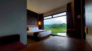 a bedroom with a bed and a large window at Aura Syaria Guest House in Bukittinggi
