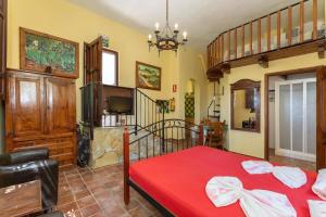 a bedroom with a red bed and a staircase at Castle Tower apartment BERNARD in rural holiday park in Tolox +40 photos