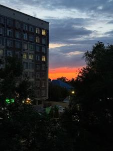 ein Gebäude mit Sonnenuntergang im Hintergrund in der Unterkunft The Bishkek Nest in Bischkek