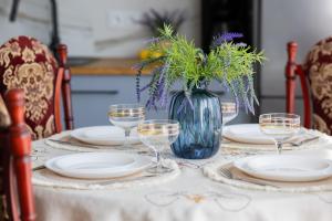 a table with plates and glasses and a vase with flowers at Spacious Apartment Close to Warsaw for 5 people by Noclegi Renters in Konstancin-Jeziorna