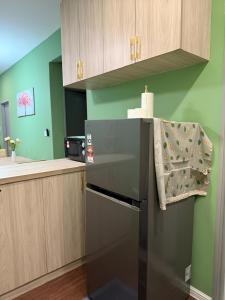 a kitchen with a black refrigerator with a towel on it at Cameron Palas Homestay in Brinchang +13 photos