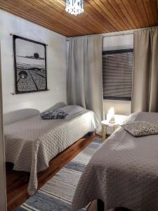 a bedroom with two beds and a window at Levi Petsukkarinne Apartment in Kittilä +17 photos