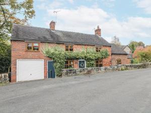 a red brick house with a white garage at Yoxall Cottage in Alton
