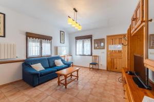 a living room with a blue couch and a tv at Casa De Los Abuelos in Ortigosa del Monte