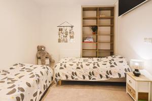 ein Schlafzimmer mit 2 Betten und einem Bücherregal in der Unterkunft Mas Lac Blanc Terrace Sauna Parking in Orbey