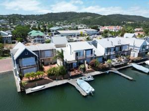 an aerial view of a house with a boat in the water at Gem Quays Waterfront one Bedroom in Knysna +11 photos