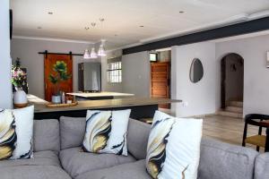 a living room with a gray couch with pillows at Newcastle Country Retreat in Newcastle