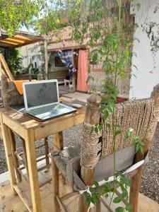 a laptop computer sitting on a wooden table on a patio at Cozy 1BR Bungalow with Kitchen in Eco Garden Nature Escape in Agadir +31 photos