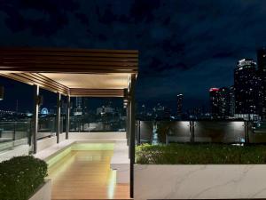 a night view of a balcony with a city skyline at The Prestige Living Bangkok at Sathorn-Chan in Bangkok