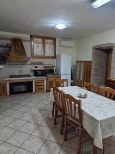 eine Küche mit einem Tisch mit Stühlen und einer weißen Tischdecke in der Unterkunft Casa Erre in Lusciano