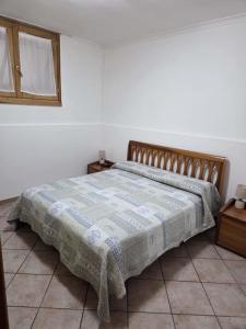 ein Schlafzimmer mit einem Bett mit einer Decke darauf in der Unterkunft Casa Erre in Lusciano