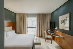 Un dormitorio con cama, escritorio y televisión. en Dorma Coliseum, en Santander