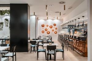 桑坦德Dorma Coliseum的有桌椅和酒吧的餐厅