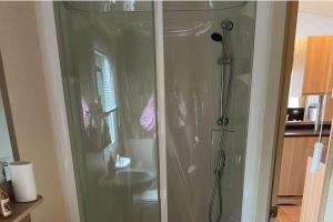 a shower stall in a bathroom with a sink at 2 Bed Caravan-Sleeps 6-Pet Friendly in Warton +8 photos