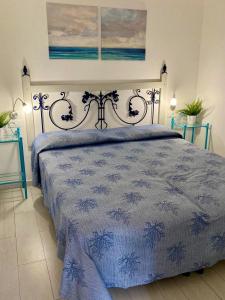 a bedroom with a bed with a blue comforter at Mono ELBA in Marina di Campo