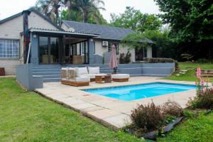 a backyard with a swimming pool and a house at Newcastle Country Retreat in Newcastle