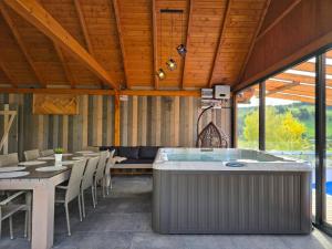 a room with a hot tub and a table and chairs at Nad Zalew dom z basenem letnim, jacuzzi i sauną, jezioro i trasa Velo Czorsztyn w pobliżu in Sromowce Wyżne